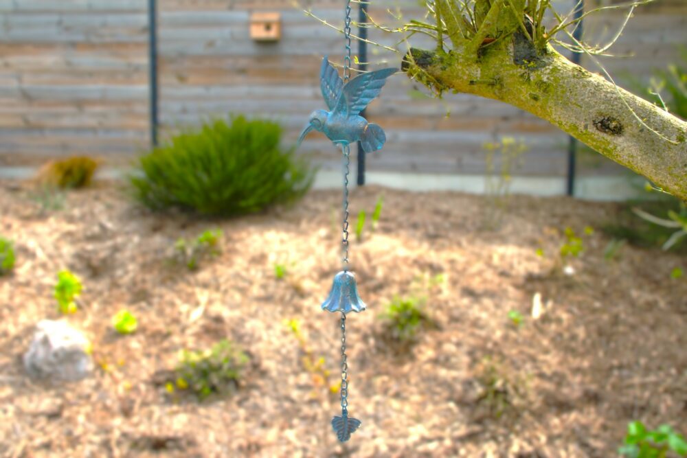 Décoration de jardin suspendue représentant un oiseau avec une clochette accrochée à un arbre