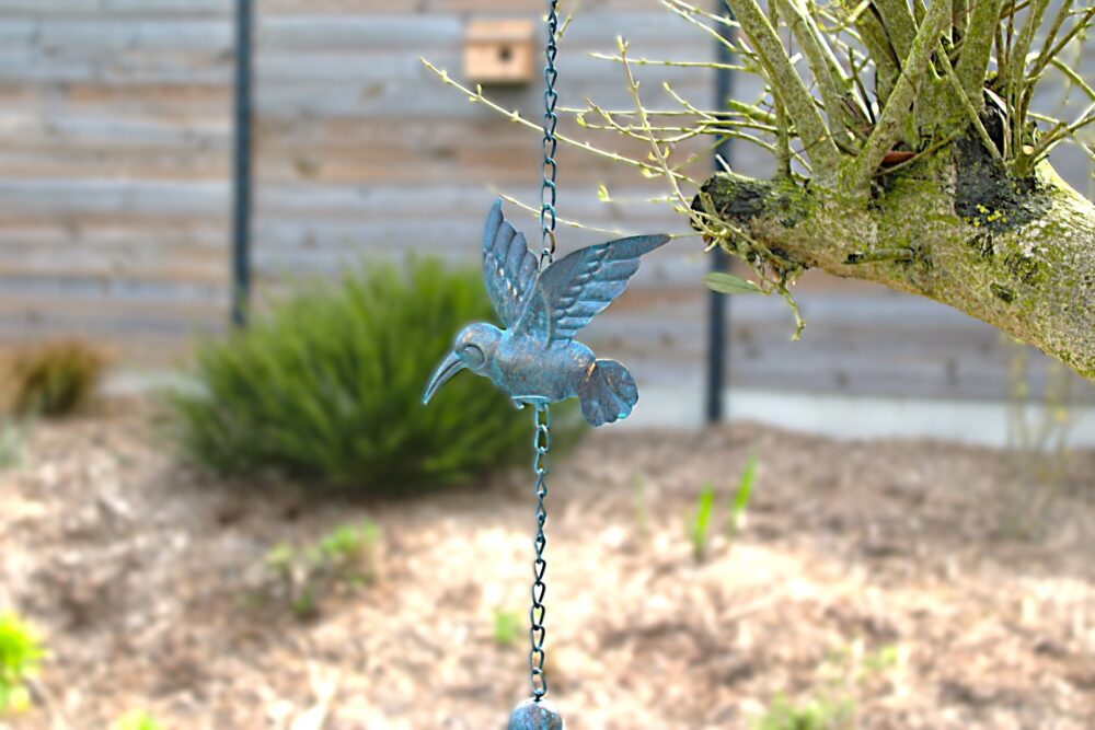 Décoration de jardin suspendue représentant un oiseau avec une clochette accrochée à un arbre