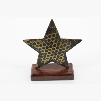 Étoile décorative en métal doré avec motifs alvéolés sur socle en bois de manguier